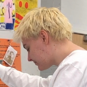 Izzy Kroese is a white non binary person with bleached short hair. 