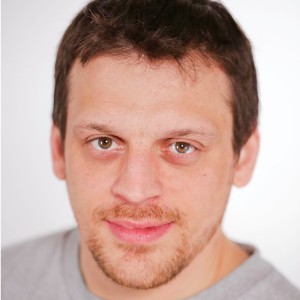 A caucasian man with brown hair and blue eyes